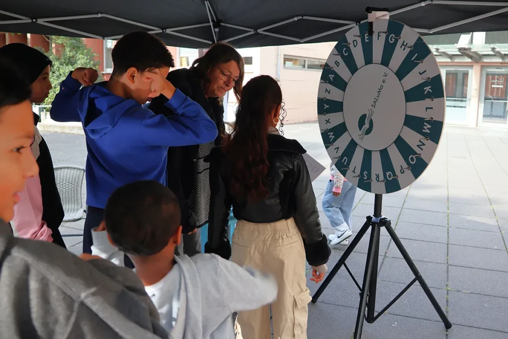 Kinder spielen Glücksrad beim „Essen mit Freunden“ Fest